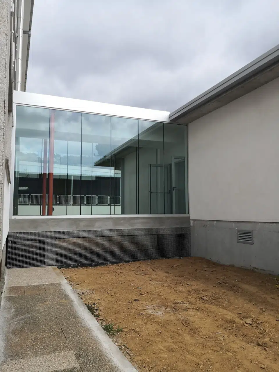 Conexión acristalada vista desde el exterior · CEIP Lamas de Abade
