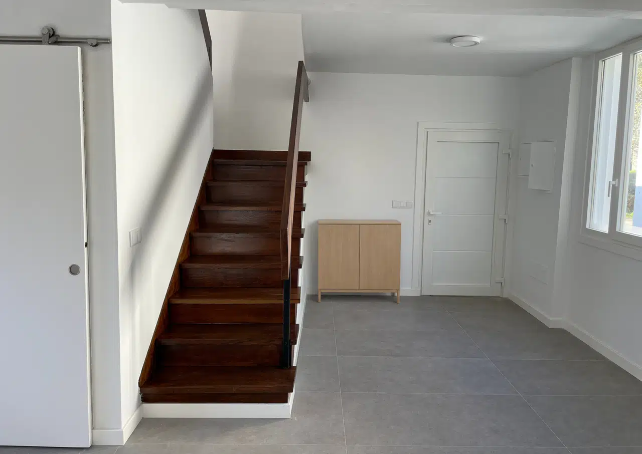 Entrada de la vivienda junto a la escalera de madera