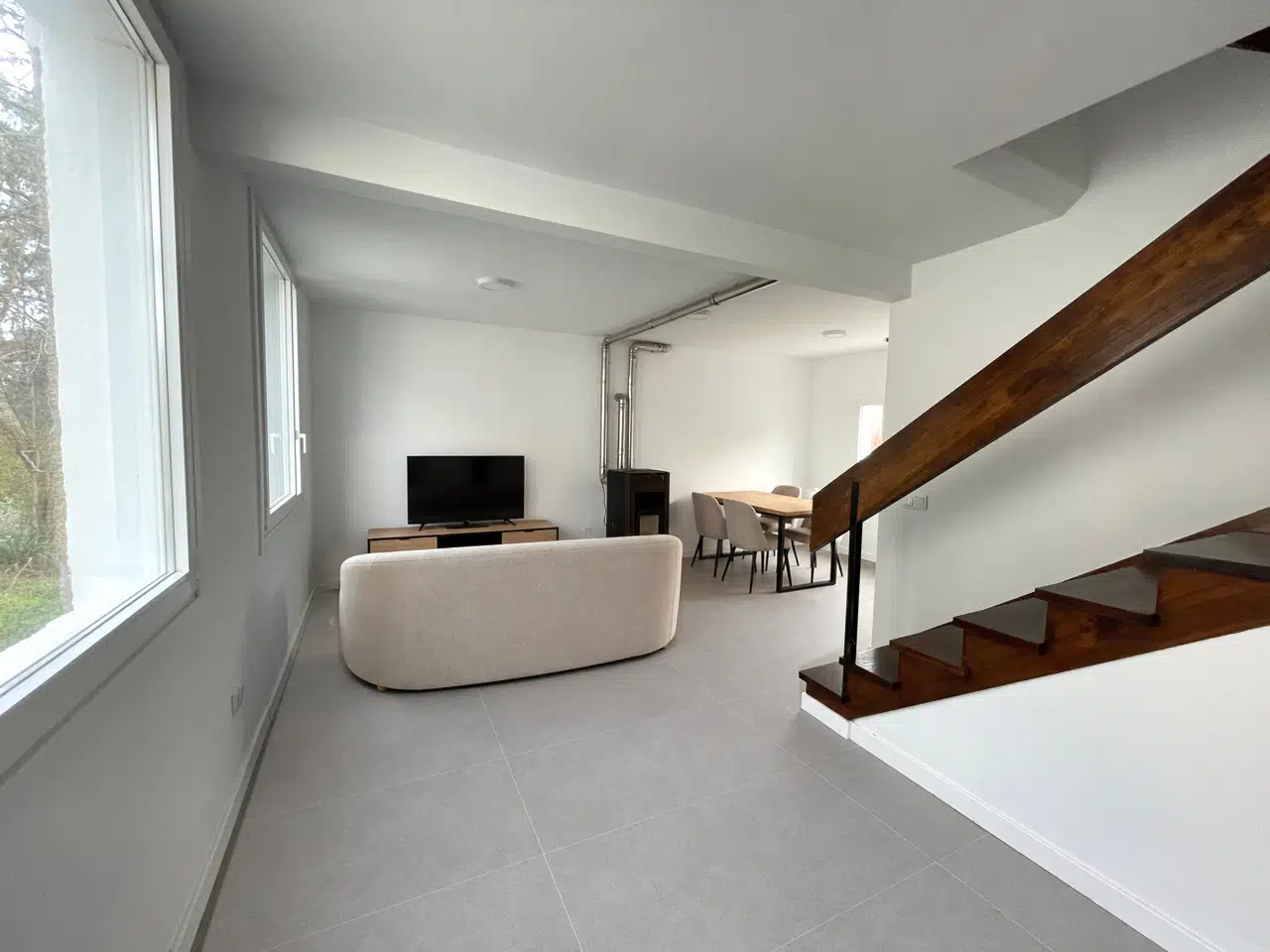 Salón rehabilitado junto a la escalera de madera conservada